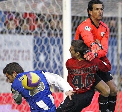 El portero osasunista Ricardo despeja el balón ante el delantero del Espanyol Raúl Tamudo 