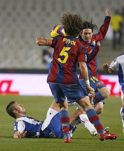 Messi y Puyol intentan recuperar la posesión. 