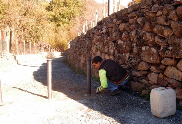 Un operario instala pivotes en un tramo del camino, en la  parroquia de Barón.