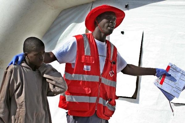  voluntario de Cruz Roja acompaña a uno de los 56 inmigrantes que han llegado en un cayuco 