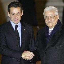 Sarkozy estrecha la mano de Mahmud Abbas.