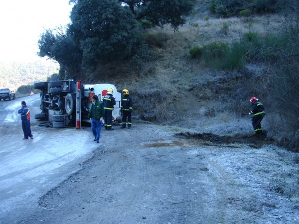 Imagen del camión volcado y los bomberos conteniendo el gasoil.