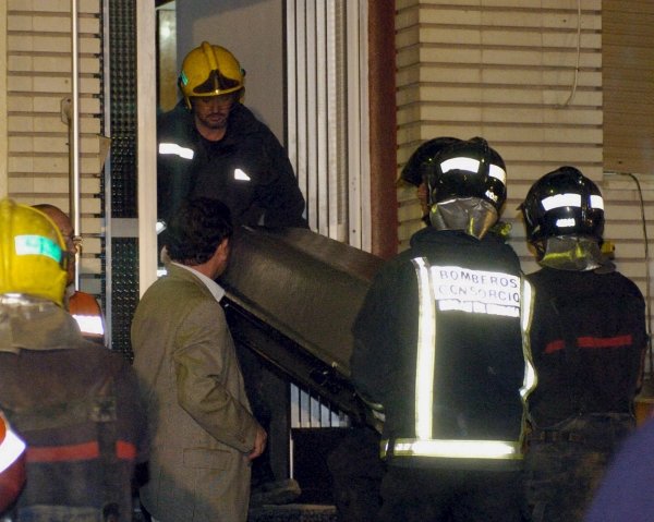 Los bomberos trasladan el cadáver de uno de los operarios fallecidos.