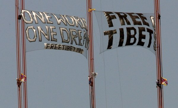 Varios activistas pro-tibetanos cuelgan unas pancartas.