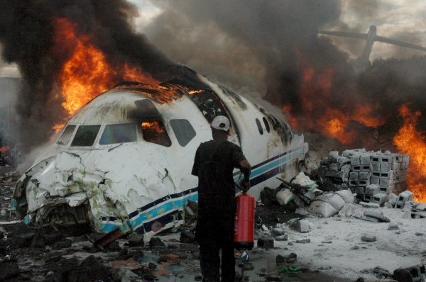 Varias personas intentan sofocar las llamas que rodean el avión.