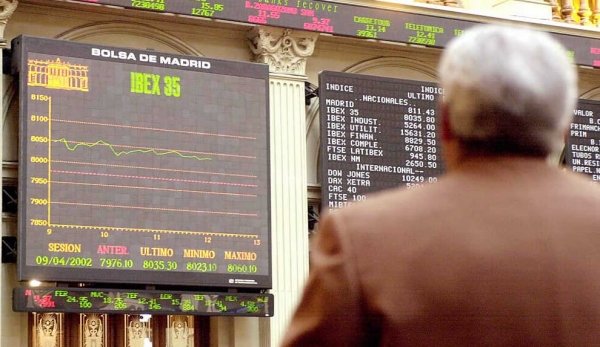 Un hombre observa un panel de valores de la Bolsa de Madrid.