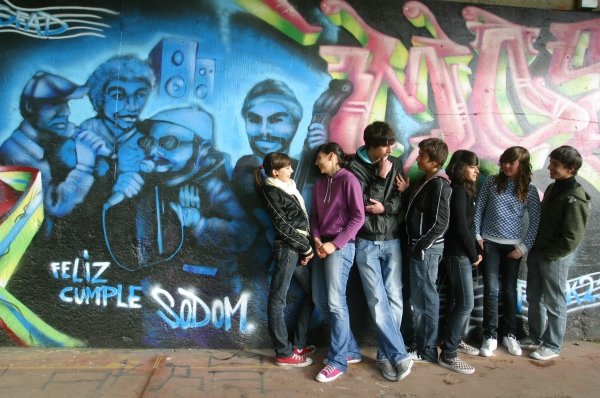 Un grupo de jóvenes junto a  un grafiti del paseo del Miño. (Foto: Daniel Atanes)