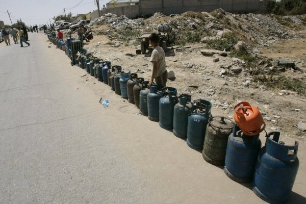 Varios palestinos hacen cola para rellenar bombonas de gas en Gaza. (Foto: Khalil Hamra)