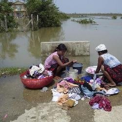 Dos mujeres lavan ropa en una de las zonas inundadas.