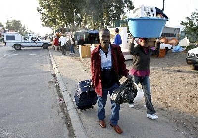 Una pareja huye con sus pertenencias tras los ataques xenófobos  (Foto: EFE)