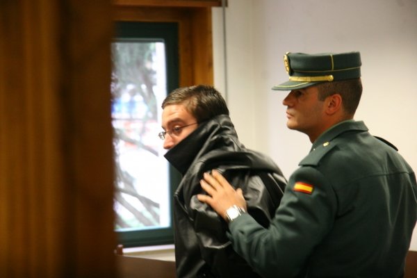 El acusado, acompañado de un agente, entra en la sala de vistas de Penal número 2. (Foto: Xesús Fariñas)