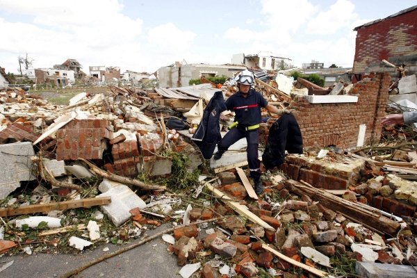 Un gendarme revisa una casa derruida por el tornado.