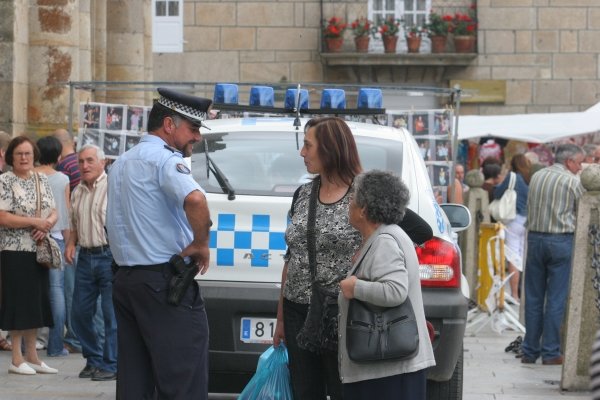 El jefe de la Policía Local de Celanova charla con dos mujeres en la feria. (Foto: Marcos Atrio)