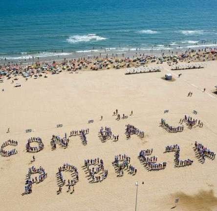 Unas 500 personas han participado hoy en la playa de Gandia en el cartel humano  (Foto: EFE)
