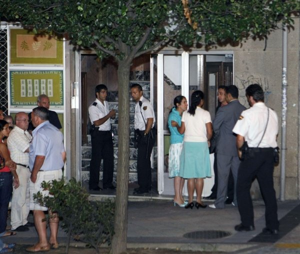 Varias personas dialogan en las puertas del edificio donde apareció muerta la mujer. (Foto: EFE)
