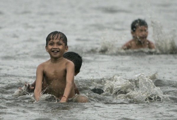 F. Malasig (Foto: Niños filipinos juegan en una calle inundada de Manila.)