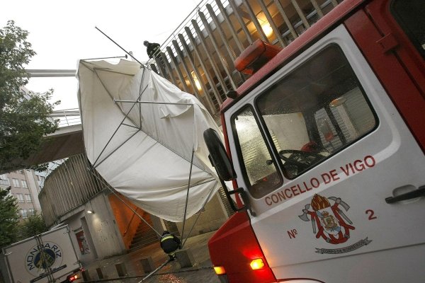 Los bomberos retirando un toldo en la calle Teófilo Llorente, en Vigo (Foto: EFE)
