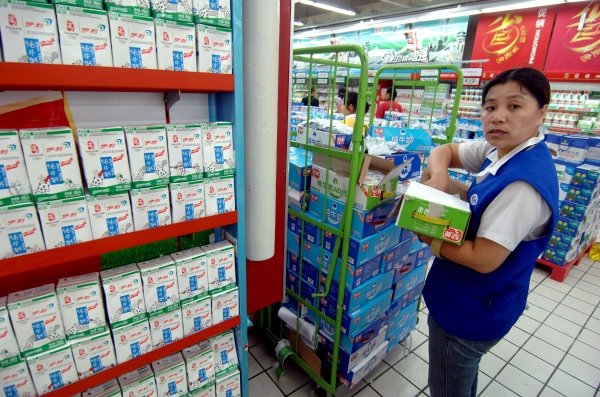 Una empleada de supermercado chino repone la estantería de leche. (Foto: Wu Hong)
