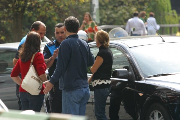 Un grupo de personas habla con un policía local tras un accidente en la ciudad.  (Foto: José Paz)