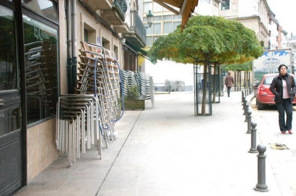 Mesas de terraza apiladas delante de dos cafeterías, en la calle Aldara. (Foto: Martiño Pinal)
