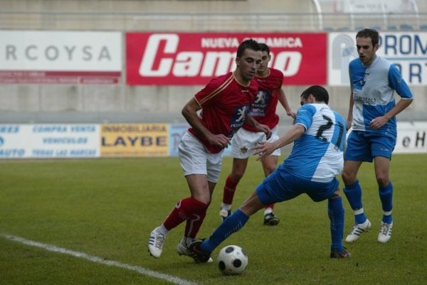 José Ángel Arenas intenta irse con el balón ante un rival del Portonovo. (Foto:   Diario de Arousa )