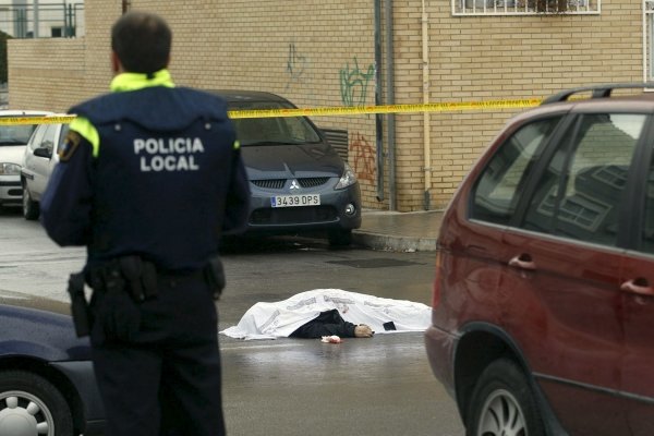 Un Policía junto al cadáver del atracador. (Foto: Morell)