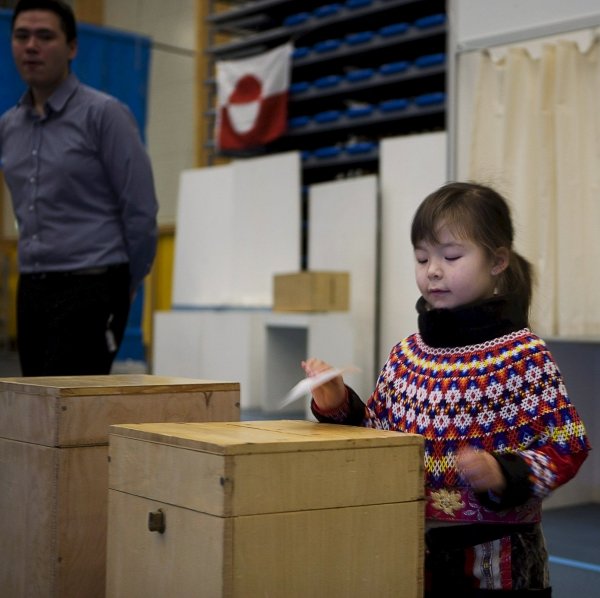 Una niña introduce en la urna el voto de su madre. (Foto: EFE)