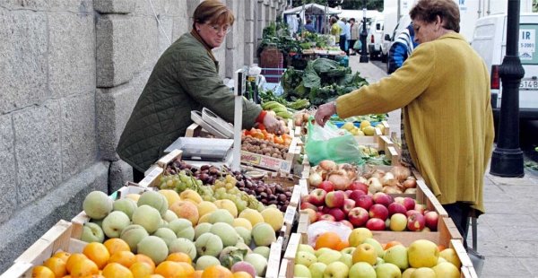 Una mujer compra fruta en un mercadillo de Cangas. (Foto: Archivo)