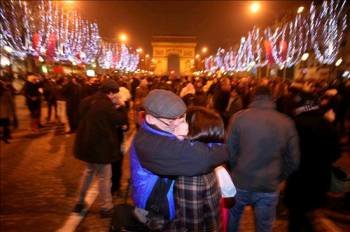 Parisinos y turistas celebran la llegada del Año Nuevo en los Campos Elíseos de París.