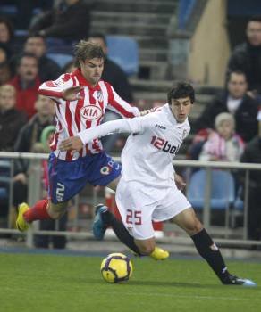 El jugador atlético Valera disputa un balón al sevillista Perotti. (Foto: Víctor Lerena)