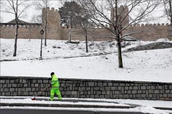 Un operario retira la nieve caída junto a la muralla de Ávila. (Foto: Raúl Sanchidrián)