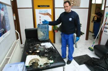 Un trabajador de limpieza muestra la camilla incendiada.  (Foto: José Paz)
