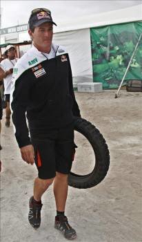 El piloto español Marc Coma carga una rueda de su motocicleta para revisarla y cambiarla por una nueva, lo cual está prohibido por el reglamento, durante la séptima etapa del Rally Dakar 2010. (Foto: Cézaro de Luca)