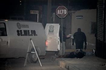 Expertos forenses recogen pruebas junto al cuerpo de una persona asesinada en Ciudad Juárez. (Foto: Luis Hinojos)