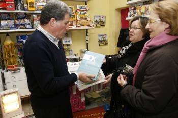 El responsable de este quiosco de la Rúa da Concordia, en Ourense, entrega un diario con el tomo a dos lectoras. (Foto: Miguel Ángel)