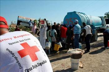 Voluntarios de Cruz Roja Española supervisan la distribución de agua potable en Puerto Príncipe. (Foto: EFE)