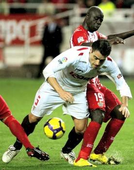 Duscher intenta pasar entre dos rivales del Almería. (Foto: José Manuel  Vidal)