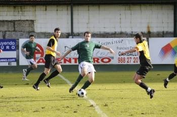 Nícol, jugador del Arenteiro y autor del único gol local, intenta regatear a un rival del Ribadumia. (Foto: Martiño Pinal )