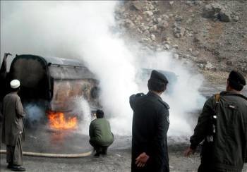 Unos miembros de las fuerzas de seguridad paquistaníes intentan sofocar las llamas de un camión cisterna.