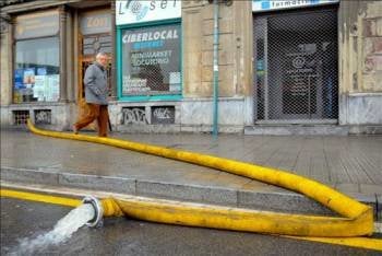 Los bomberos achican agua de un local, en Bilbao.