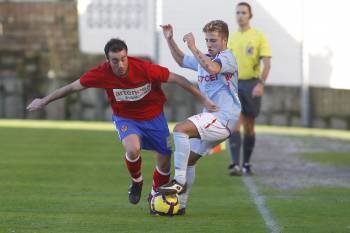 Nuno, centrocampista del C.D. Ourense, intenta irse con el balón controlado ante un rival del Celta. (Foto: AD)