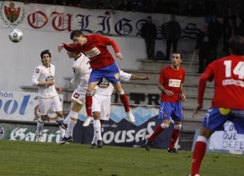 Uno de los centrales del CD Ourense despeja ante varios rivales del Deportivo B.