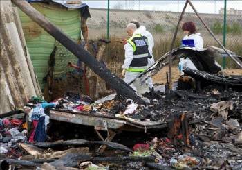 Agentes de la Policía Científica investigan entre los restos de una caravana destruída por el incendio. (Foto: JAVIER CEBOLLADA)