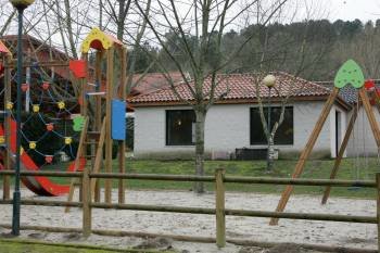 El edificio que alberga la cafetería del camping, junto al parque infantil, en el complejo turístico. (Foto: MARCOS ATRIO)