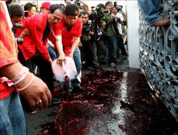 Un manifestante vierte una garrafa llena de sangre, donada por otros opositores, ante las puertas de la sede del Gobierno en Bangkok. (Foto: NARONG SANGNAK)