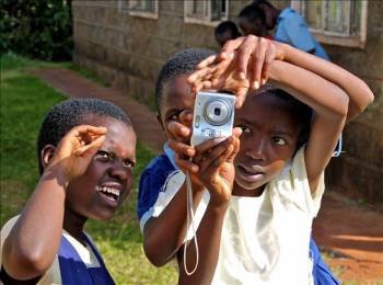 tres niños del orfanato de Cura, en Kenia, sacan fotografías. (Foto: JOSÉ CALATAYUD)