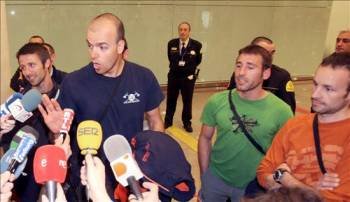 Los bomberos hablan con la prensa, a su llegada a Barcelona. (Foto: ALBERT OLIVÉ)