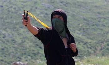Un palestino usa una honda para lanzar piedras a soldados israelíes durante los enfrentamientos ocurridos en la localidad cisjordana de Iraq Borin. (Foto: ALAA BADARNEH)