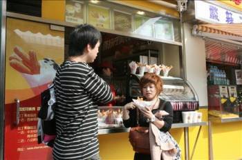 Dos jóvenes chinos compran unos churros. (Foto: MARTA MIERA)