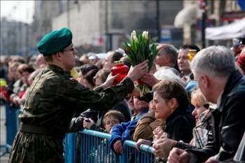 Un militar polaco recoge velas y flores de las personas concentradas a las puertas del Palacio Presidencial de Varsovia. (Foto: PAWEL SUPERNAK)